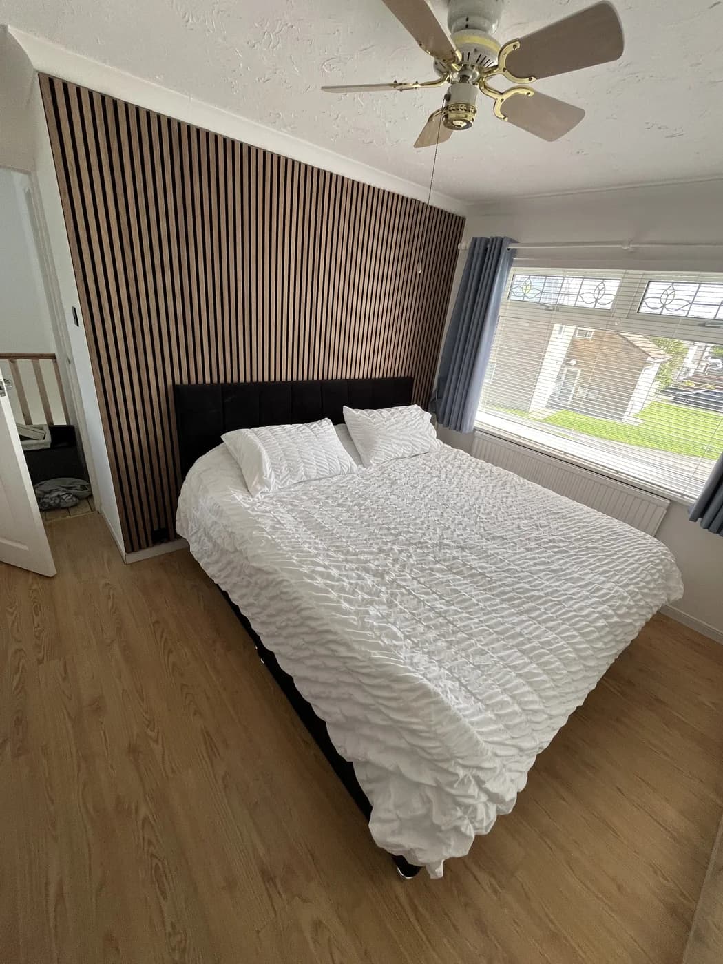 Renovated bedroom with a slatted feature wall in Bridgend by HJB