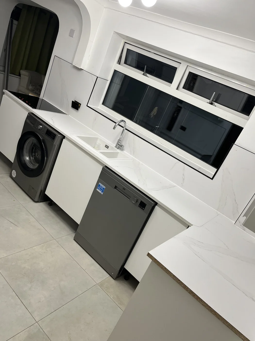 Fitted kitchen with white gloss units in a Bridgend renovation by HJB