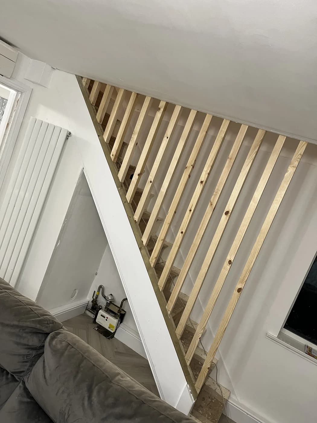 Oak slatted feature wall beside a staircase in Bridgend by HJB
