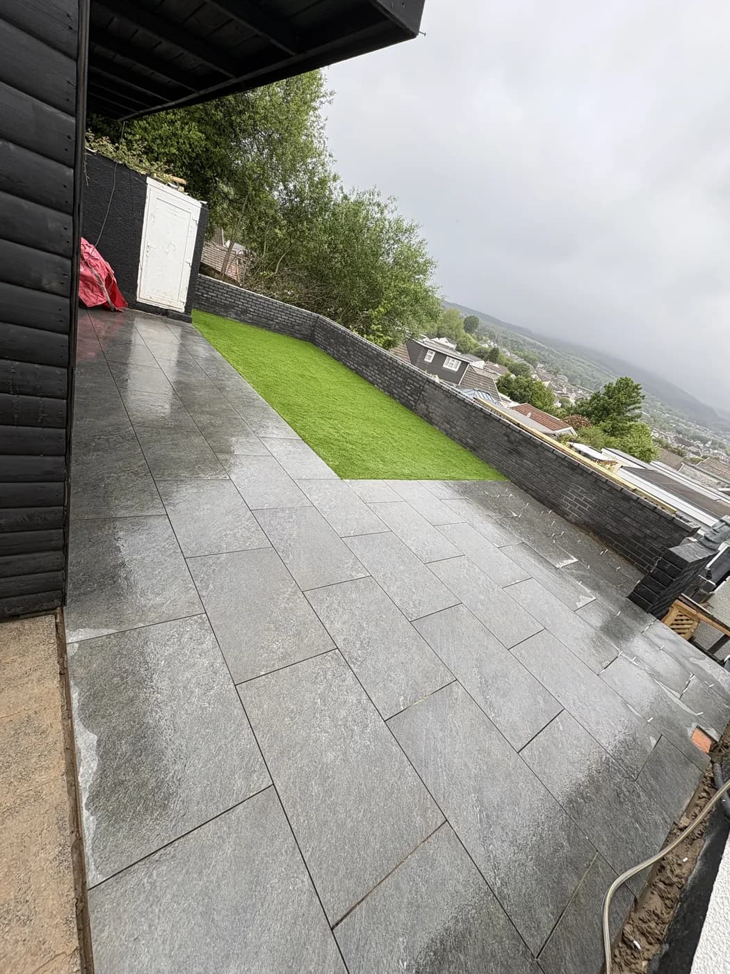 Porcelain patio and artificial lawn with a valley view in Nantymoel by HJB